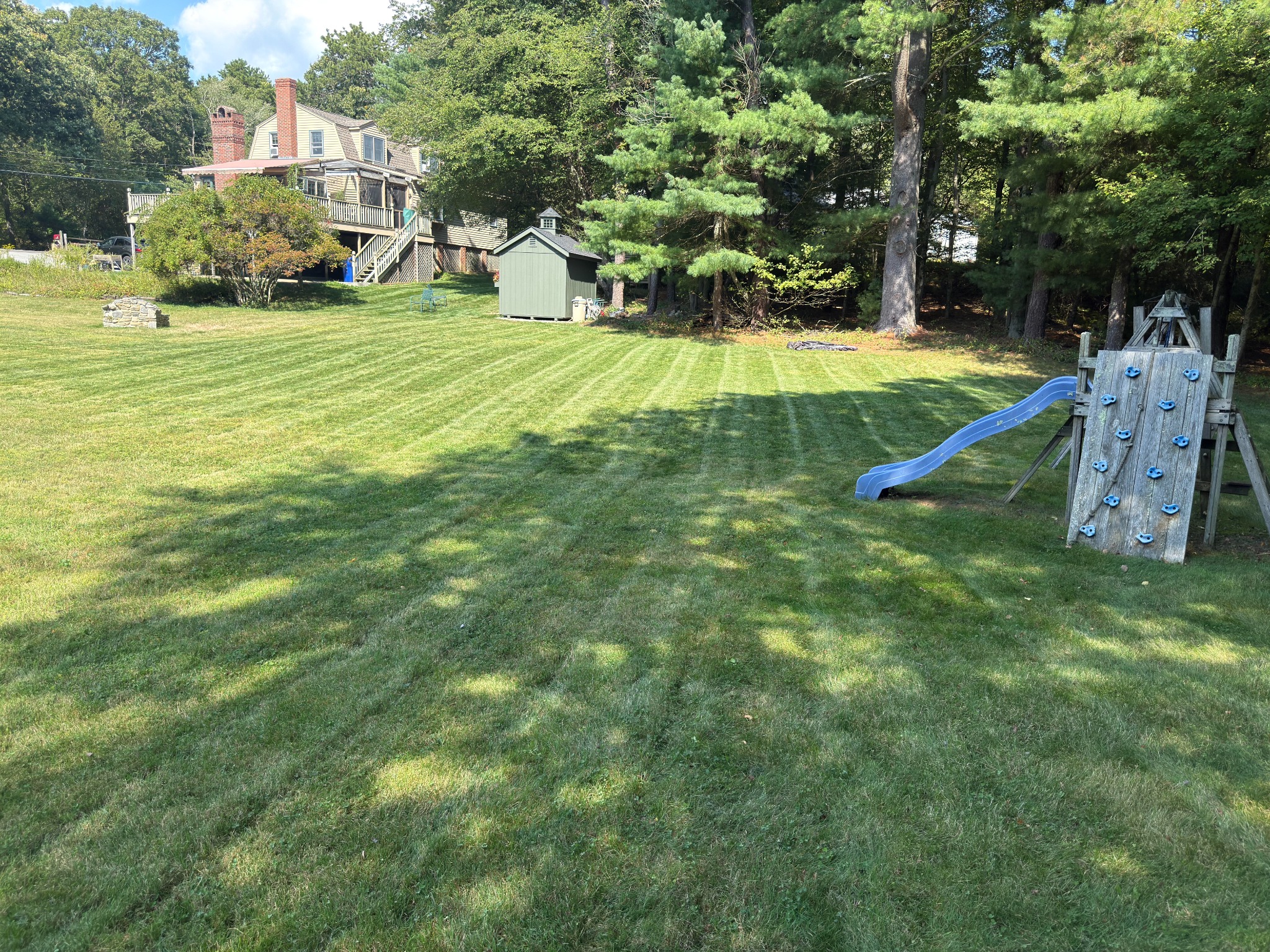 Landscaped Rhode Island style property with clean lawn and driveway