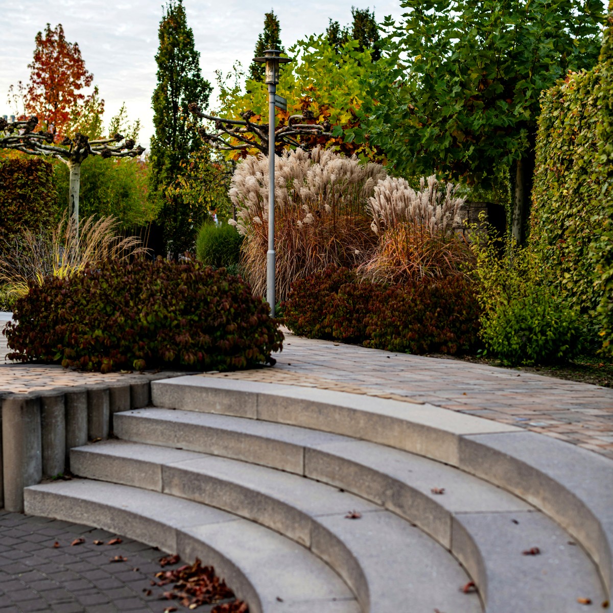 Landscaped property with stone steps and trimmed greenery